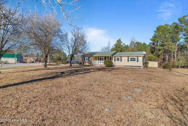 single story home featuring a porch and a front lawn