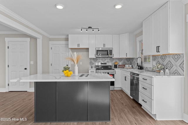 kitchen with sink, a center island, white cabinets, and appliances with stainless steel finishes