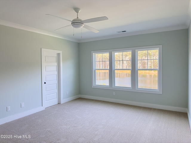 spare room featuring crown molding, light colored carpet, a healthy amount of sunlight, and ceiling fan