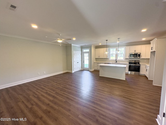 kitchen featuring white cabinetry, sink, dark wood-type flooring, stainless steel appliances, and a kitchen island