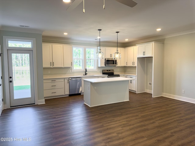 kitchen featuring a center island, white cabinets, hanging light fixtures, dark hardwood / wood-style floors, and appliances with stainless steel finishes