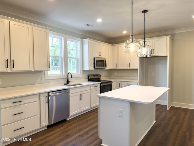 kitchen with white cabinetry, sink, pendant lighting, a kitchen island, and appliances with stainless steel finishes