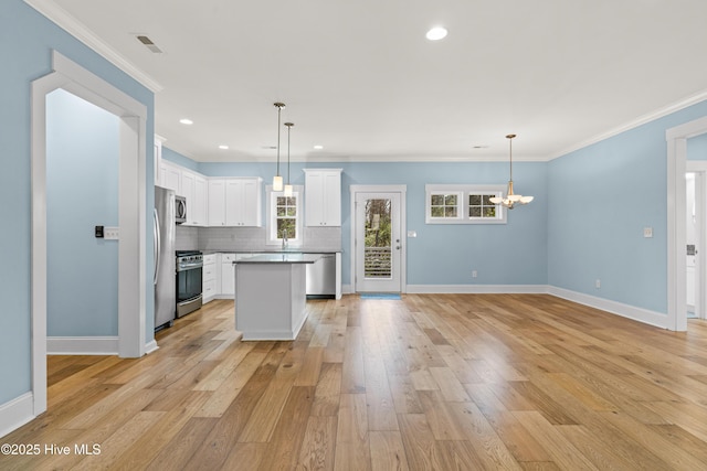kitchen featuring baseboards, a notable chandelier, stainless steel appliances, and light wood-type flooring