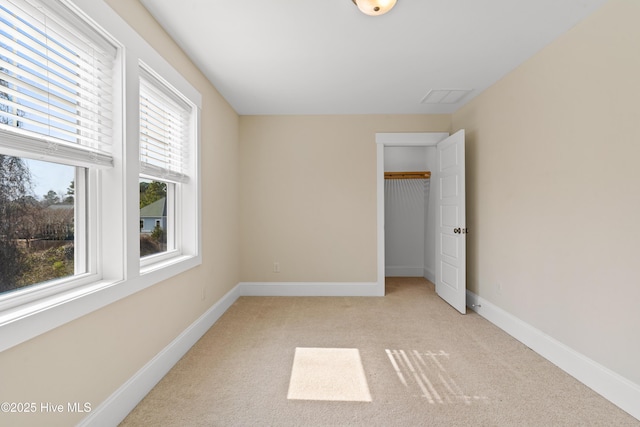 unfurnished bedroom with light colored carpet, a closet, and baseboards