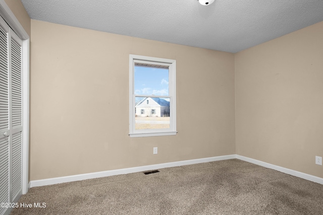 unfurnished bedroom with a closet, carpet flooring, and a textured ceiling