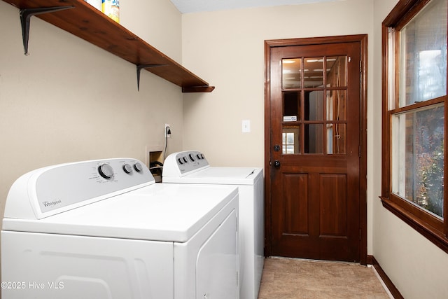 clothes washing area featuring a wealth of natural light and independent washer and dryer