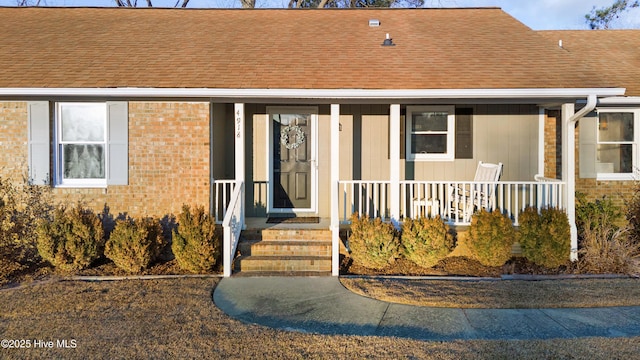 view of exterior entry featuring covered porch