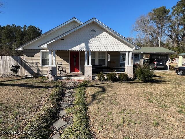 view of front of house with a front yard and a carport