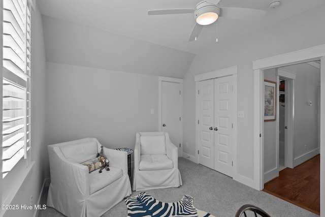 living area featuring ceiling fan, lofted ceiling, and carpet floors