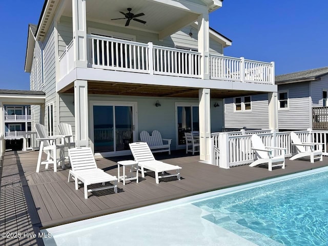 back of house featuring ceiling fan, a balcony, and a swimming pool side deck