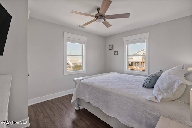 bedroom with multiple windows, ceiling fan, and dark wood-type flooring