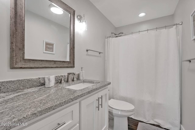 full bathroom featuring toilet, vanity, hardwood / wood-style floors, and shower / tub combo with curtain