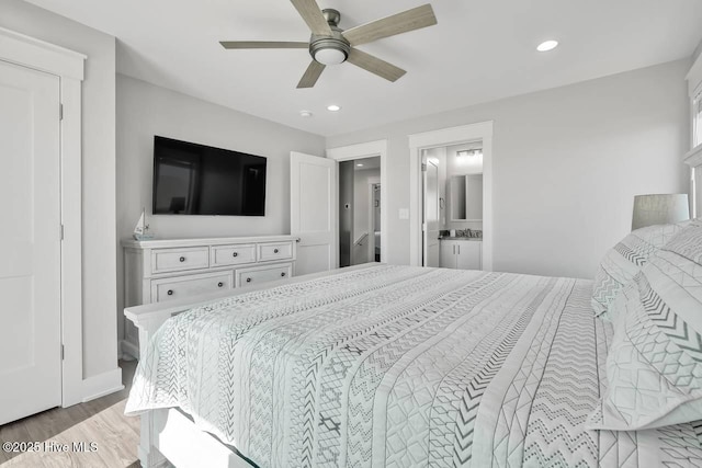 bedroom with ceiling fan, light hardwood / wood-style flooring, and connected bathroom