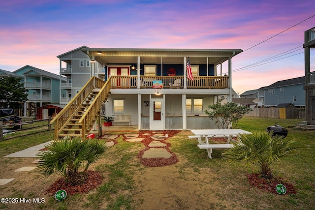 view of front of house featuring a balcony and a yard