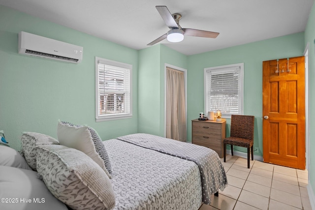 bedroom featuring a wall unit AC, multiple windows, ceiling fan, and light tile patterned flooring