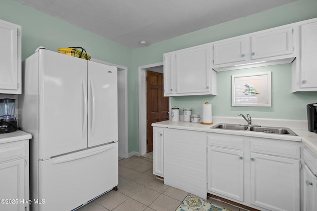 kitchen featuring white cabinets, white refrigerator, and sink