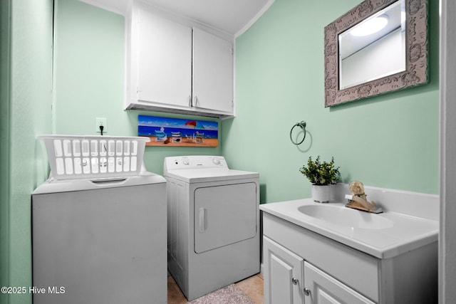 clothes washing area with cabinets, washing machine and dryer, and sink