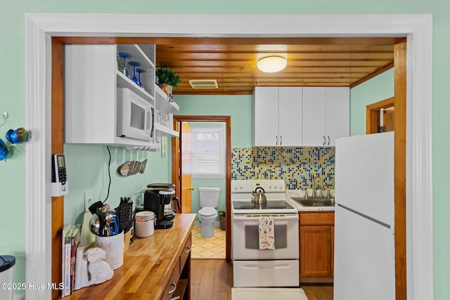 kitchen with tasteful backsplash, sink, wood ceiling, and white appliances