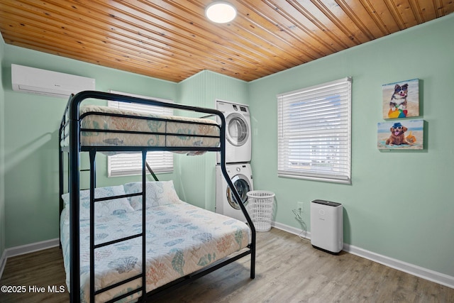 bedroom with a wall mounted AC, multiple windows, stacked washer / dryer, and wooden ceiling