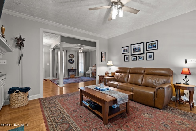 living room featuring a textured ceiling, light hardwood / wood-style flooring, ceiling fan, and ornamental molding