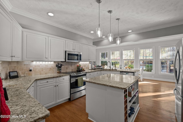 kitchen featuring a kitchen island, white cabinets, a textured ceiling, and appliances with stainless steel finishes