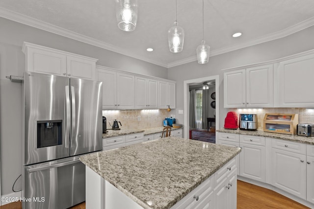 kitchen with a center island, white cabinetry, and stainless steel fridge with ice dispenser