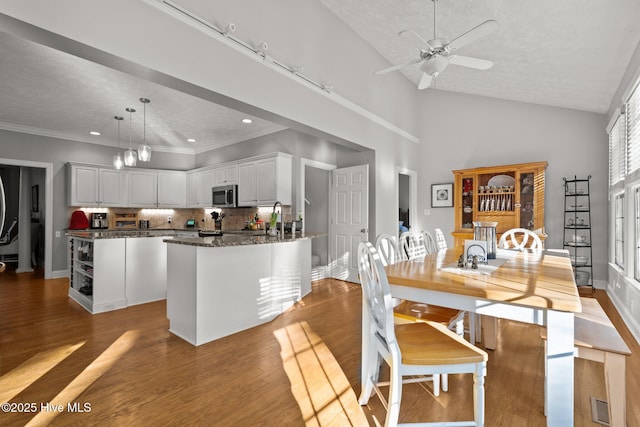 dining room featuring a textured ceiling, light hardwood / wood-style flooring, ceiling fan, and lofted ceiling