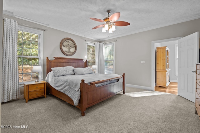 carpeted bedroom featuring ceiling fan, crown molding, and a textured ceiling