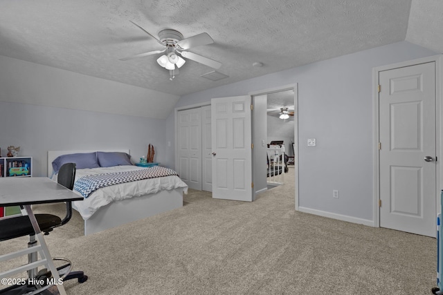 carpeted bedroom featuring ceiling fan, a closet, a textured ceiling, and vaulted ceiling