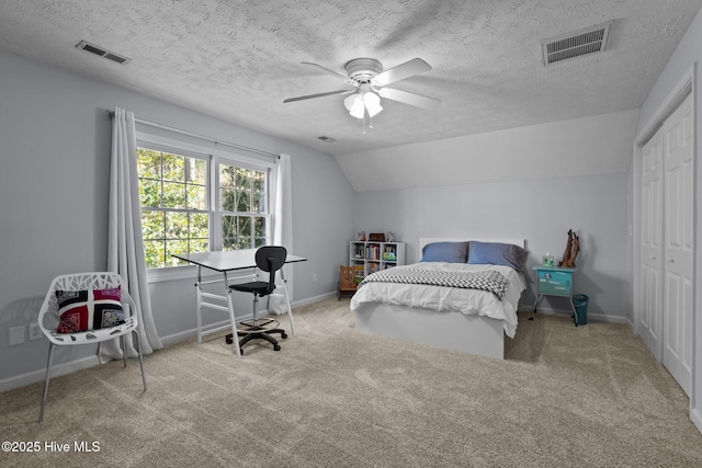 carpeted bedroom with a textured ceiling, ceiling fan, a closet, and lofted ceiling