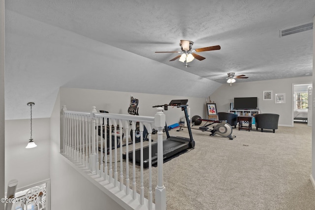 exercise area featuring a textured ceiling, ceiling fan, lofted ceiling, and carpet floors