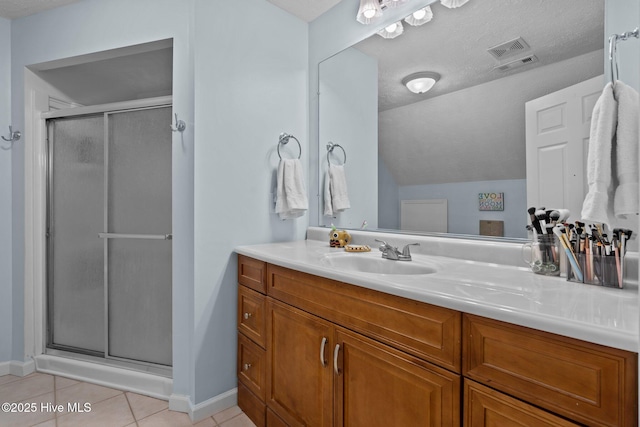 bathroom featuring a textured ceiling, vanity, a shower with door, tile patterned flooring, and lofted ceiling