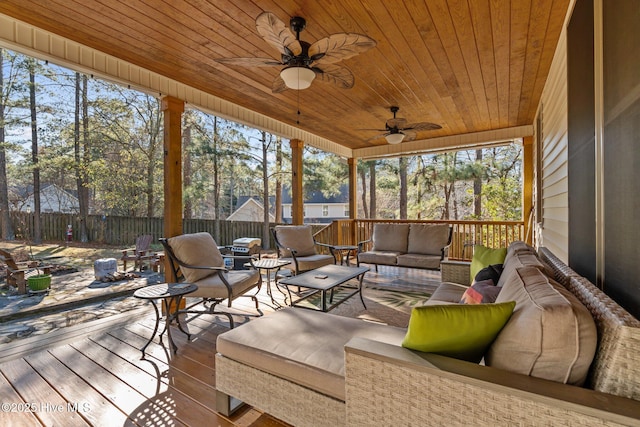 sunroom with ceiling fan and wooden ceiling