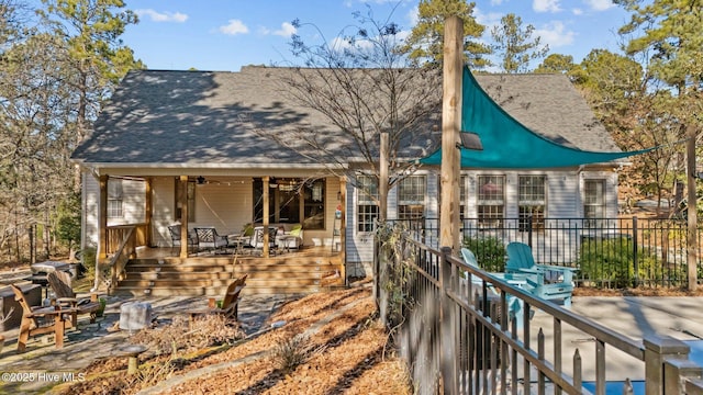 back of property featuring ceiling fan and a patio