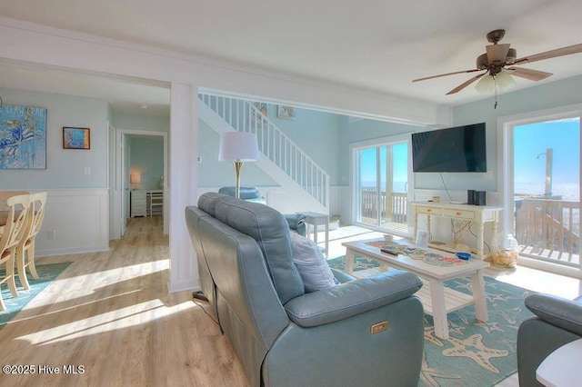 living room featuring ceiling fan and light hardwood / wood-style floors