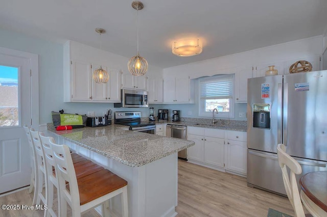 kitchen featuring appliances with stainless steel finishes, white cabinets, sink, and kitchen peninsula