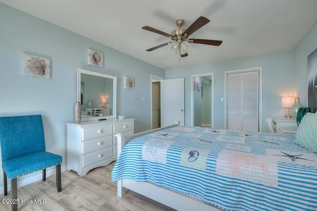 bedroom featuring ceiling fan, light hardwood / wood-style flooring, and a closet