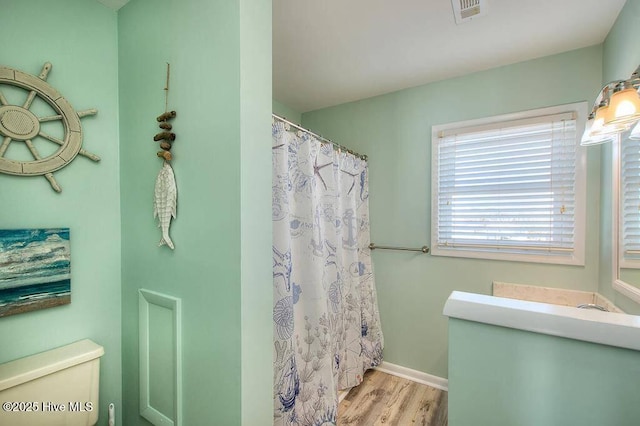 bathroom with toilet, wood-type flooring, and a shower with shower curtain