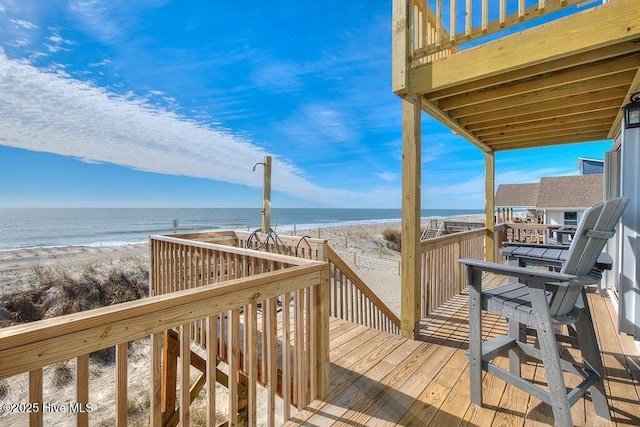 wooden terrace with a view of the beach and a water view