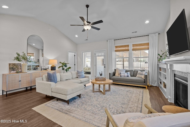 living room featuring vaulted ceiling, ceiling fan, and dark wood-type flooring