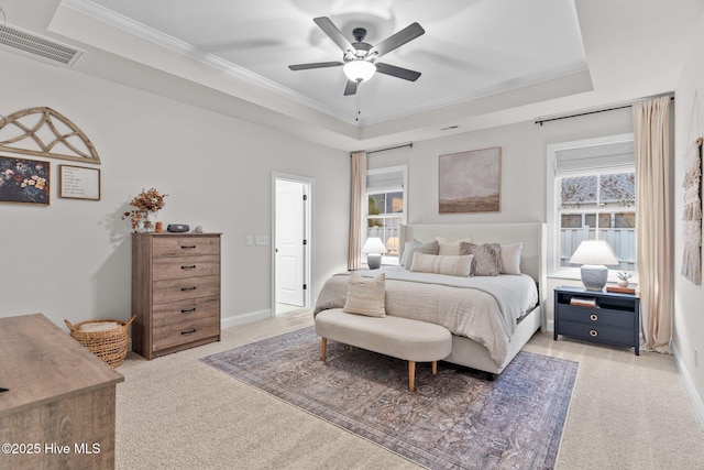 bedroom featuring a raised ceiling, ceiling fan, light carpet, and ornamental molding