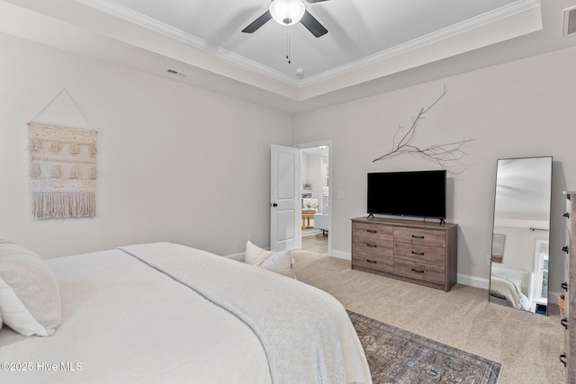 bedroom with ceiling fan, ornamental molding, light carpet, and a tray ceiling