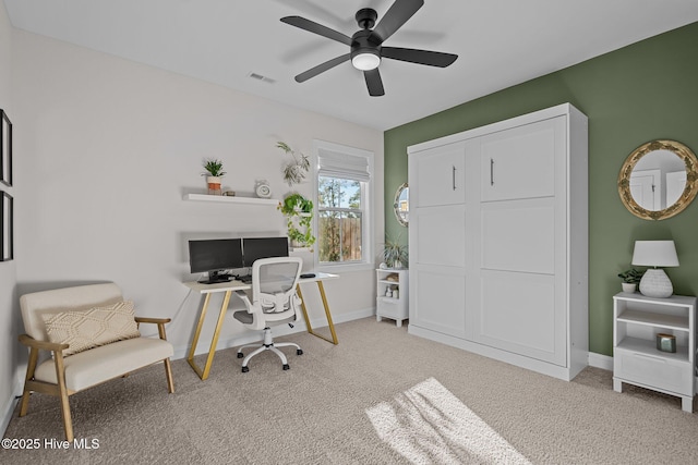 carpeted office space with ceiling fan