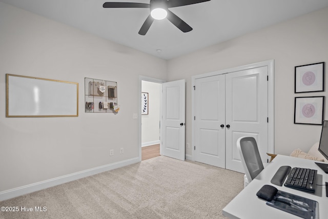 unfurnished office with ceiling fan and light colored carpet