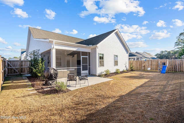 rear view of property with ceiling fan, a patio area, and a sunroom