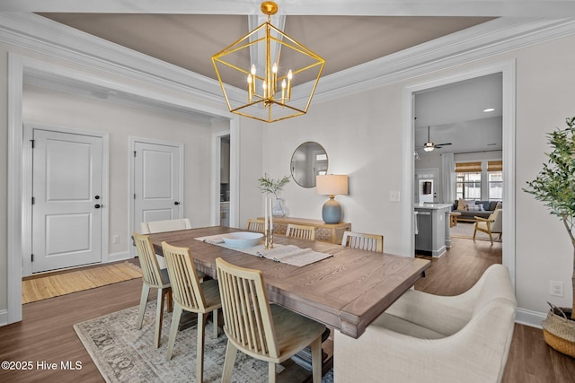 dining space featuring ceiling fan with notable chandelier, dark hardwood / wood-style flooring, and ornamental molding