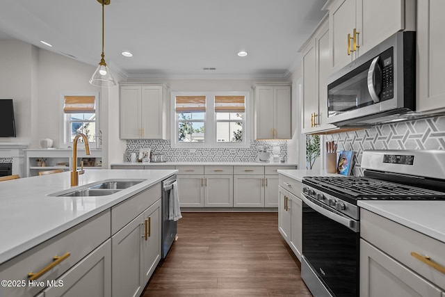 kitchen with hanging light fixtures, sink, white cabinets, and stainless steel appliances