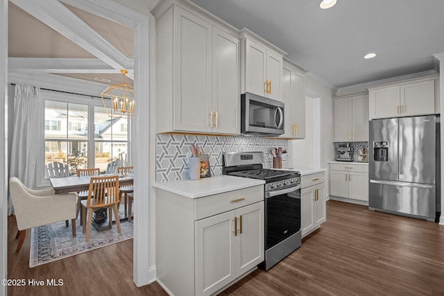 kitchen featuring backsplash, white cabinets, stainless steel appliances, and dark wood-type flooring