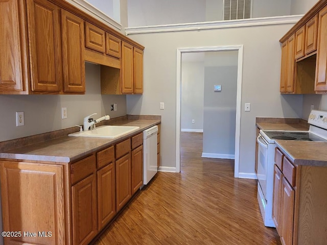 kitchen with white appliances, light hardwood / wood-style flooring, and sink