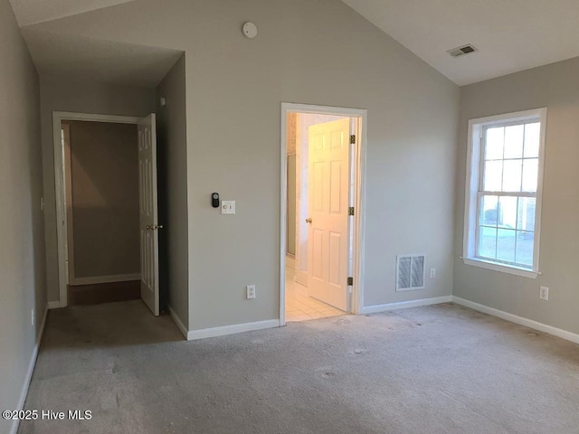 unfurnished bedroom featuring light colored carpet and lofted ceiling